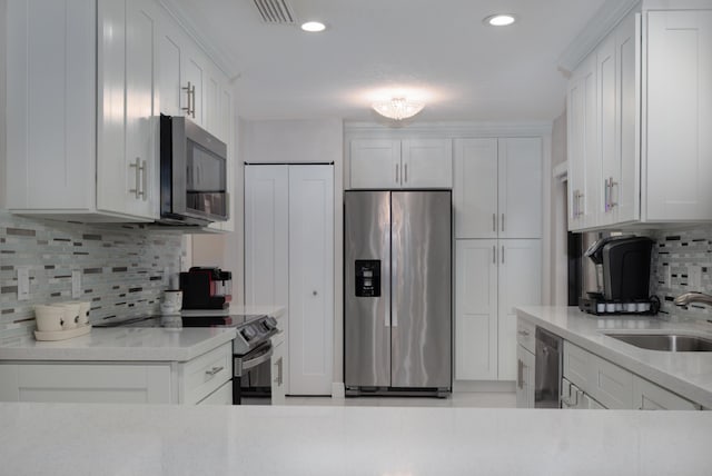 kitchen featuring appliances with stainless steel finishes, white cabinets, and a sink