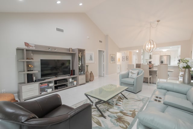 living room featuring high vaulted ceiling, light tile patterned floors, visible vents, and a chandelier