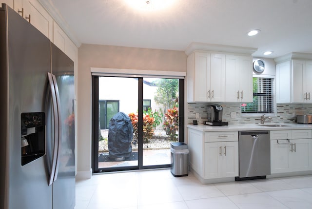 kitchen featuring light countertops, appliances with stainless steel finishes, a sink, and white cabinets