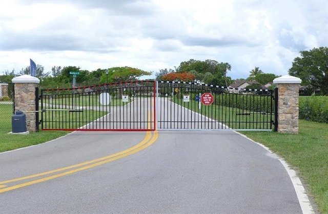 view of gate with a lawn