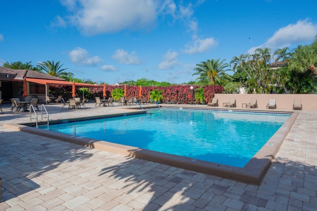 community pool featuring a patio area and fence