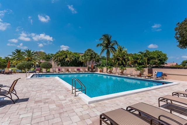 pool with a patio area and fence