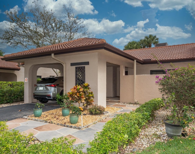 exterior space with a tiled roof, aphalt driveway, and stucco siding