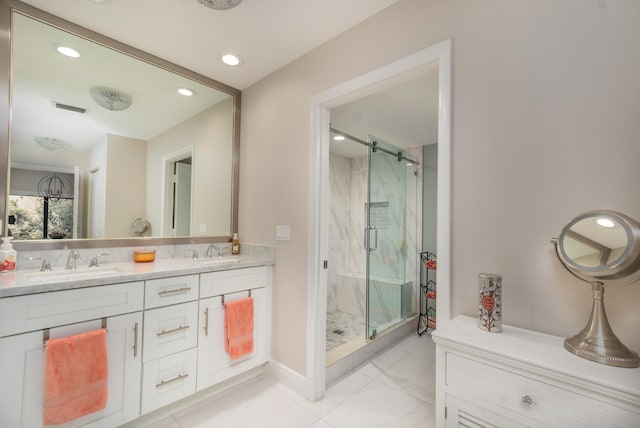 full bathroom with double vanity, a marble finish shower, visible vents, and a sink