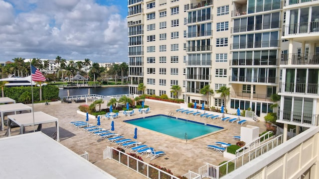 view of swimming pool with a water view and a patio area