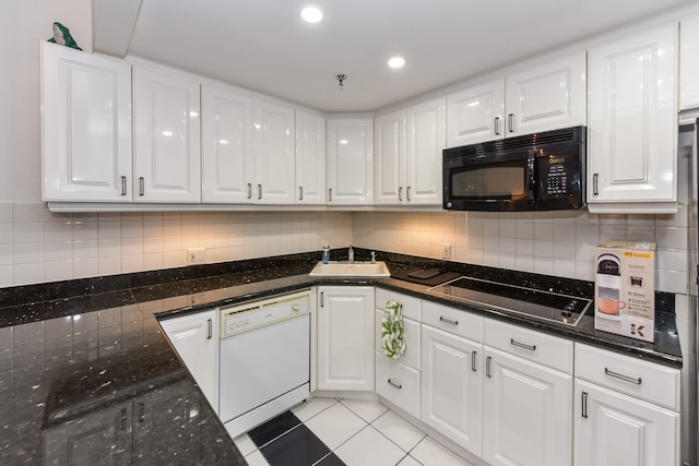 kitchen with sink, light tile patterned floors, dark stone countertops, black appliances, and white cabinets