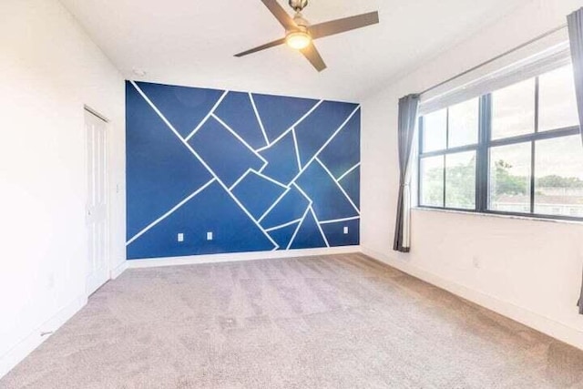 empty room featuring ceiling fan and carpet flooring