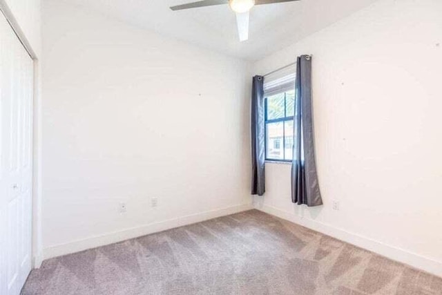 empty room with ceiling fan and carpet