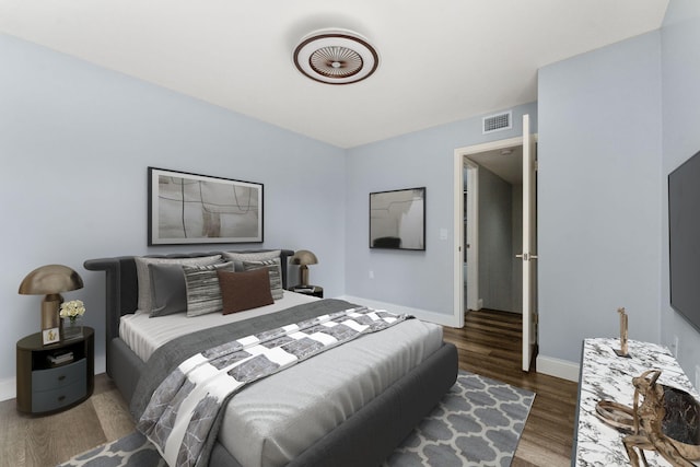 bedroom with dark hardwood / wood-style flooring