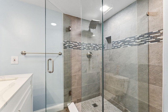 bathroom with vanity and a shower with door