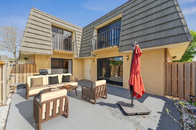 back of house featuring a balcony, an outdoor hangout area, and a patio area