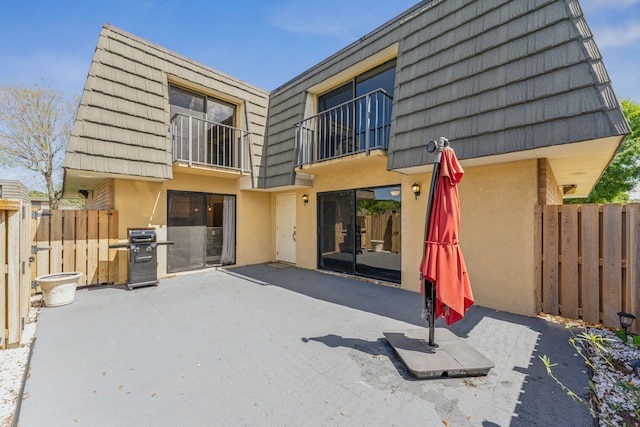 back of house with a balcony and a patio