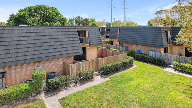 view of yard featuring a balcony and central air condition unit