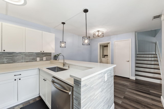 kitchen with white cabinetry, hanging light fixtures, stainless steel dishwasher, kitchen peninsula, and light stone countertops