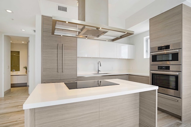 kitchen featuring sink, white cabinetry, island range hood, black electric cooktop, and stainless steel double oven