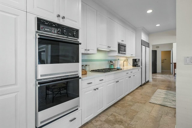 kitchen featuring appliances with stainless steel finishes, white cabinetry, and tasteful backsplash