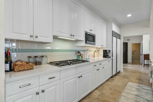 kitchen featuring white cabinets, appliances with stainless steel finishes, and decorative backsplash