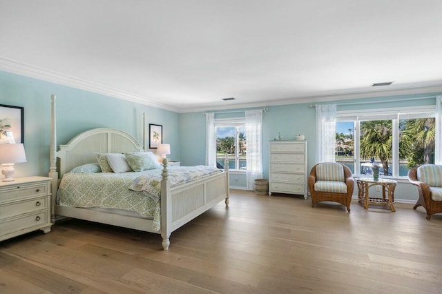 bedroom with light wood-type flooring and crown molding