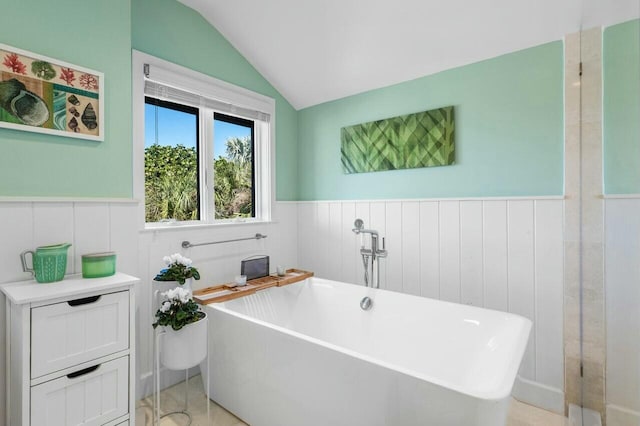 bathroom with a tub to relax in and lofted ceiling