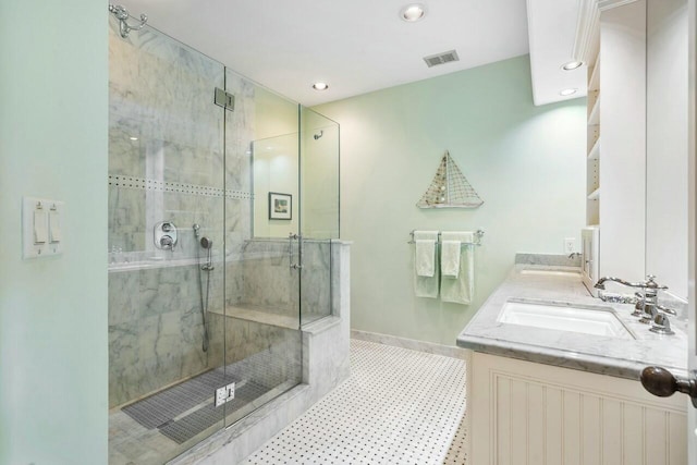 bathroom featuring tile patterned floors, vanity, and a shower with door