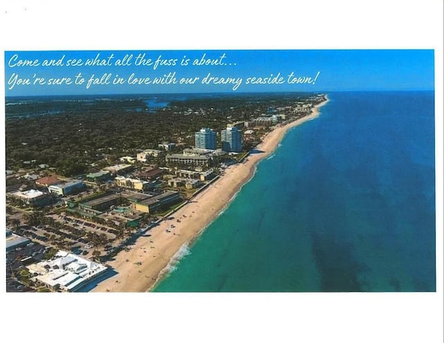 birds eye view of property featuring a beach view and a water view