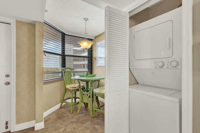 laundry room with stacked washer / dryer and a textured ceiling