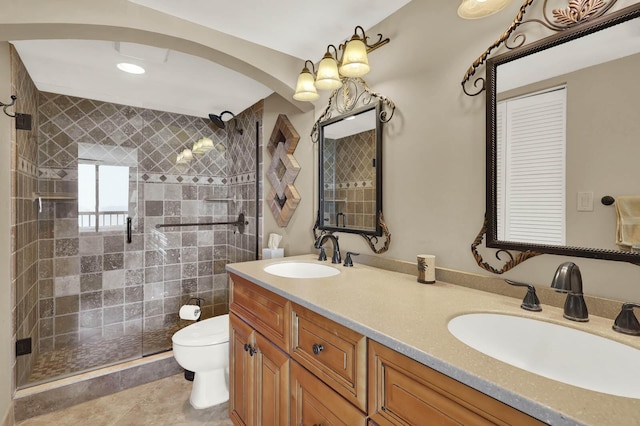 bathroom with tile patterned floors, vanity, toilet, and a shower with door