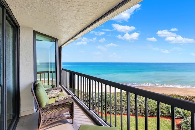 balcony featuring a water view and a view of the beach