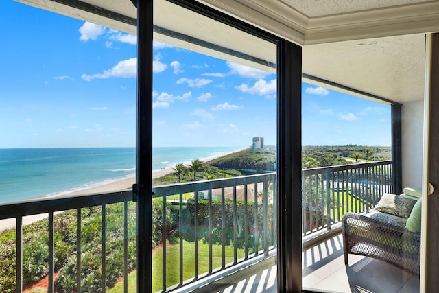 balcony featuring a view of the beach and a water view