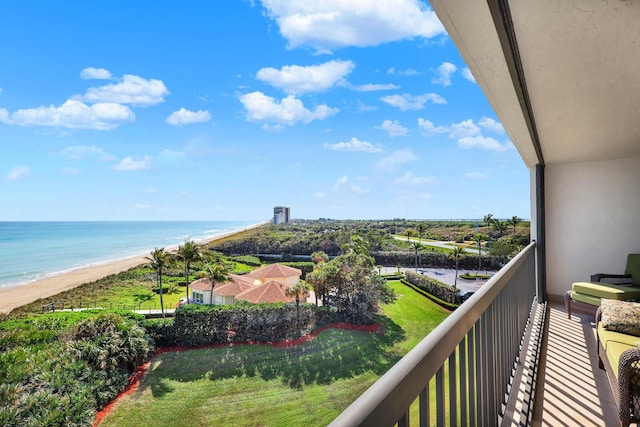 balcony featuring a view of the beach and a water view