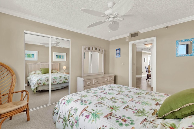 bedroom with ornamental molding, a closet, a textured ceiling, and carpet