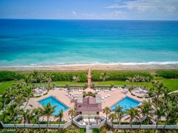 drone / aerial view featuring a water view and a beach view