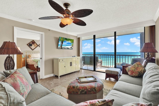 living room featuring ceiling fan, crown molding, a wall of windows, and a textured ceiling