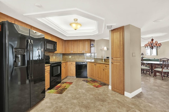 kitchen featuring black appliances, backsplash, ornamental molding, a tray ceiling, and light stone countertops