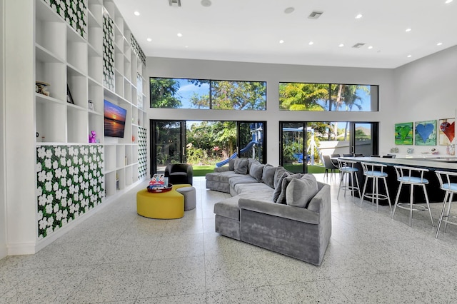 living room featuring a healthy amount of sunlight, a high ceiling, visible vents, and recessed lighting