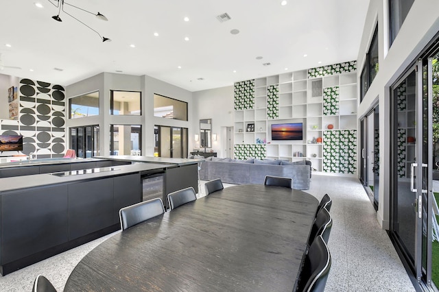 dining space featuring visible vents, built in features, wine cooler, light speckled floor, and recessed lighting