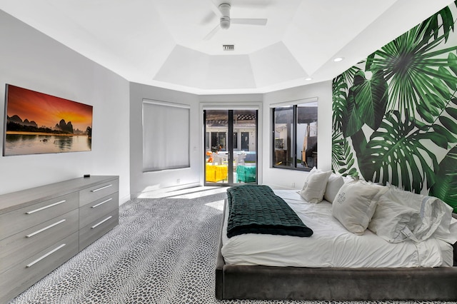 bedroom with recessed lighting, light colored carpet, a ceiling fan, access to outside, and a tray ceiling