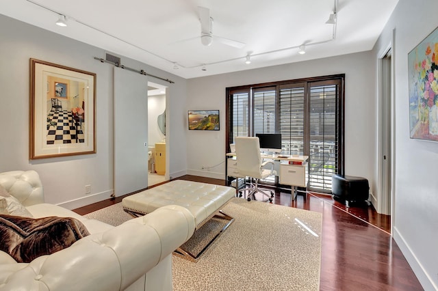 living room featuring a barn door, baseboards, ceiling fan, dark wood-style flooring, and track lighting