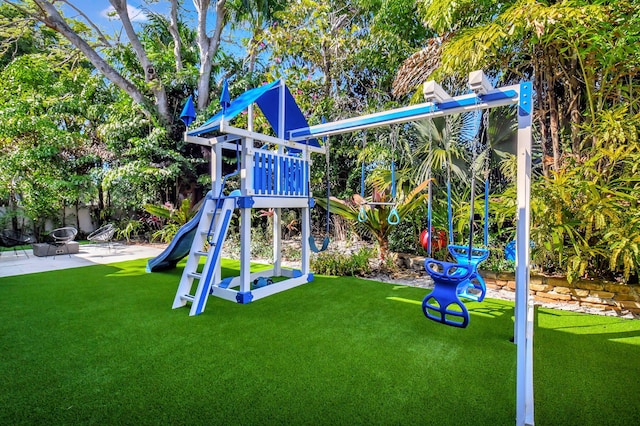 view of playground featuring a patio and a lawn