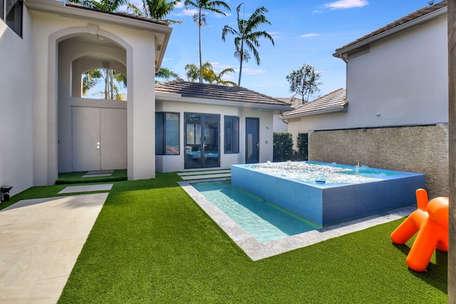 exterior space with entry steps, a tiled roof, a lawn, stucco siding, and a hot tub