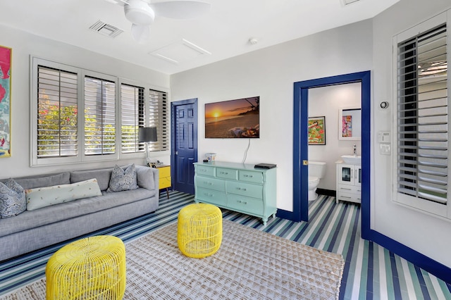 living area featuring carpet floors, attic access, visible vents, and baseboards