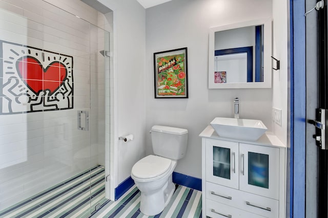 bathroom featuring a stall shower, baseboards, vanity, and toilet