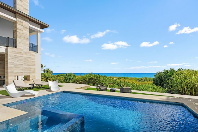 view of pool with an in ground hot tub, a water view, and a patio area