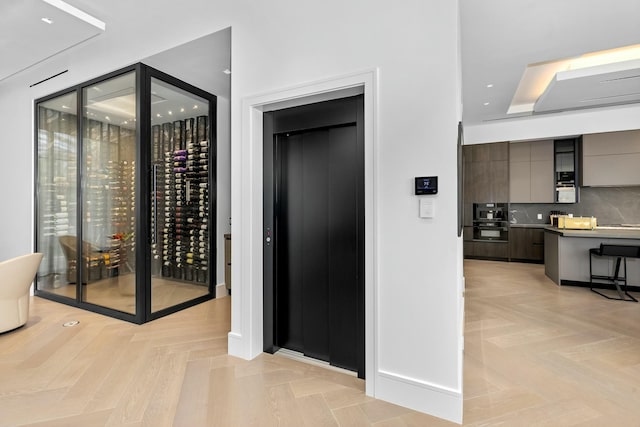 wine room with light parquet flooring and elevator