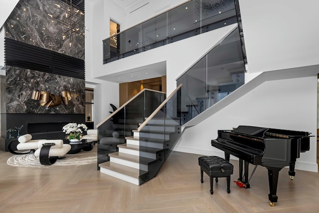 staircase with parquet floors and a high ceiling