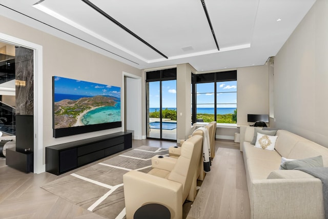 living room with a tray ceiling and light parquet floors