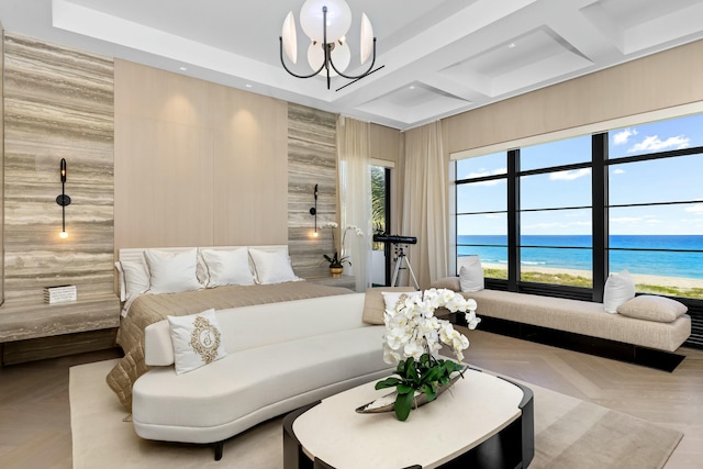 bedroom with an inviting chandelier, light parquet flooring, and a water view