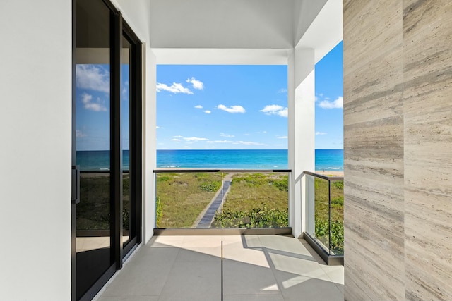 balcony featuring a water view and a beach view