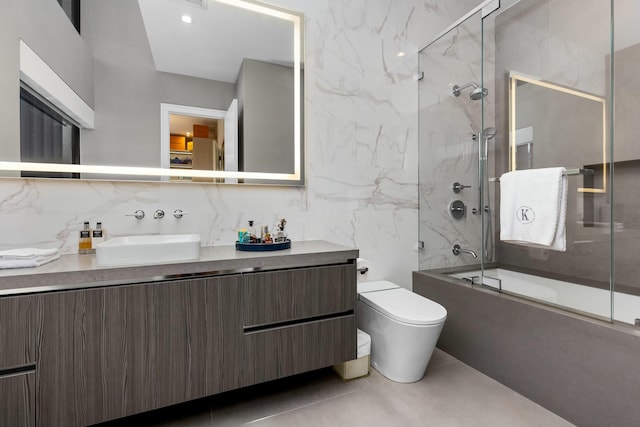 full bathroom with toilet, tasteful backsplash, bath / shower combo with glass door, tile walls, and vanity