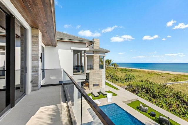 balcony featuring a water view and a beach view